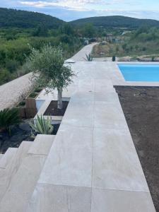 a concrete walkway next to a swimming pool at Villa Lavender in Felsőörs +13 photos