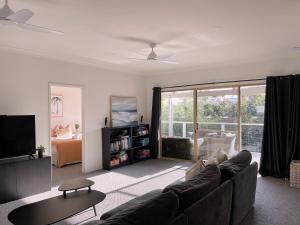 Una sala de estar con un sofá y un televisor. en Eagle Bay Summerhaus, en Dunsborough