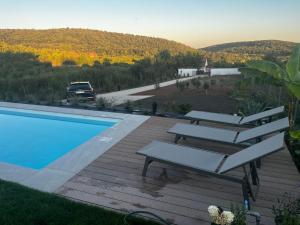 a pool with lounge chairs and a view of a mountain at Villa Lavender in Felsőörs