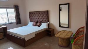 a bedroom with a large bed and a mirror at Hotel Times Stay in Udaipur