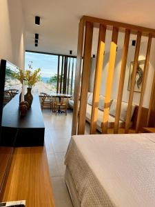 a bedroom with a bed and a table with flowers on it at Beira mar porto de pedras essence C101 in Pôrto de Pedras