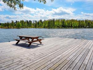 a picnic table sitting on a dock near the water at Serene Seaside Retreat in Adelso-By Traum in Adelsö