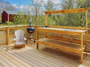 a wooden deck with a hot tub and a chair at Serene Seaside Retreat in Adelso-By Traum in Adelsö +13 photos