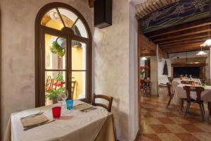 ein Esszimmer mit einem Tisch und einem Fenster in der Unterkunft Locanda Al Centrale in Caprino Veronese