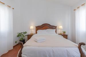 a bedroom with a large white bed with two lamps at Blue House Burgau in Burgau