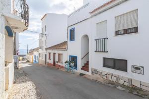 an alley with white buildings and a bike parked on a street at Blue House Burgau in Burgau +16 photos