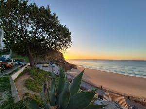 a view of the beach and the ocean at sunset at Blue House Burgau in Burgau