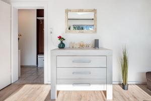 a white dresser in a living room with a mirror at Ferienwohnung Deister Blick in Rodenberg +18 photos