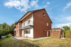 a brick house with a balcony and a yard at Ferienwohnung Deister Blick in Rodenberg