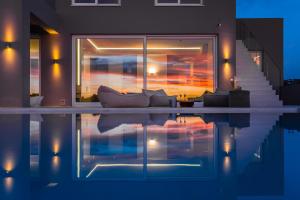 a living room with a couch next to a swimming pool at White Grace - A Seductive World of Luxury in Pigi