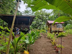 a man standing in front of a house at Loh jinawi Guest House Bunaken in Bunaken
