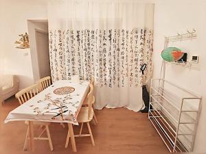 a dining room with a table and a curtain at Qingdao Linlin Tranquil Residence in Qingdao +13 photos