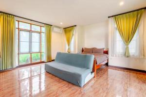 a bedroom with a couch and a bed and windows at Green Heaven Bungalow 2 in Mae Nam