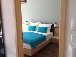 a bedroom with a bed with blue pillows at Vízparti wellness apartman Velence in Velence