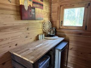 a wooden counter in the corner of a tiny house at Akmens sala in Vecpiebalga