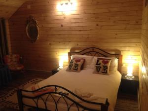 a bedroom with a bed with two lights on it at Pensiunea Carmen in Bucium