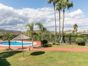 a resort with a swimming pool with palm trees at Alhaurín Villa with Terrace in Alhaurín el Grande