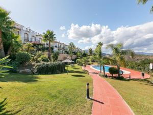 a resort yard with a swimming pool and palm trees at Alhaurín Villa with Terrace in Alhaurín el Grande