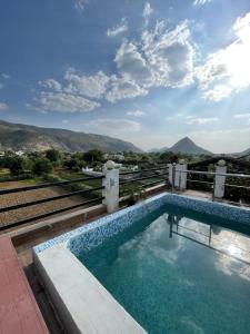 a swimming pool on a building with mountains in the background at Café The Wall in Pushkar