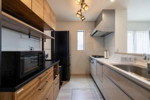 a kitchen with a sink and a black refrigerator at Fukuoka Airport 5 in Shime