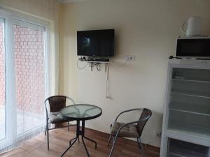 a room with a table and two chairs and a tv at Vízparti apartmanok in Szántód