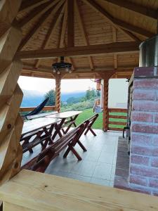 a wooden pavilion with picnic tables on a patio at Casa MAN in Mărişel