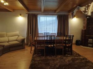 a living room with a table and chairs and a couch at Casa MAN in Mărişel