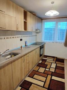 a kitchen with wooden cabinets and a sink at Casa MAN in Mărişel +3 photos