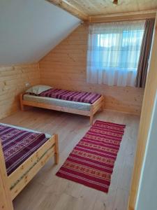 a room with two beds and two rugs in it at Casa MAN in Mărişel