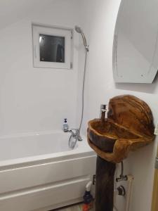 a bathroom with a wooden sink and a bath tub at Casa MAN in Mărişel