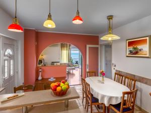 ein Esszimmer mit roten Wänden sowie einem Tisch und Stühlen in der Unterkunft Apartment Nika in Opatija