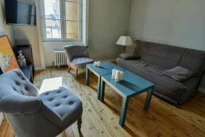 a living room with a couch and a table at Les Parfums de Madeleine in Montbrison