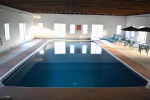 a swimming pool in a large room with tables and chairs at Cavendish Memotree Resort in Cavendish