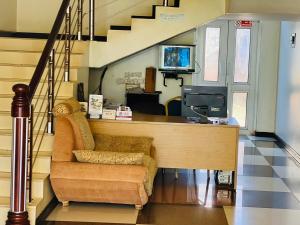 a living room with a desk and a chair and stairs at Hotel Royal Nest Entebbe in Entebbe