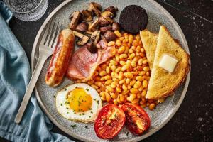 a plate of breakfast food with eggs bacon beans and toast at Ace Airport Transit Hotel in Katunayaka