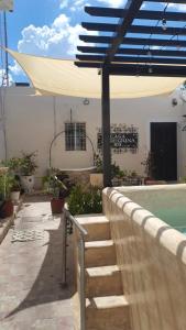 a patio with a swimming pool and a blue umbrella at Casa Peregrina 613 in Mérida