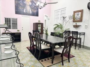a dining room with a black table and chairs at Casa Peregrina 613 in Mérida