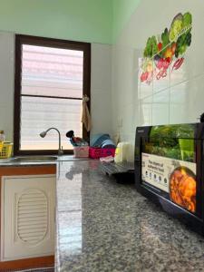 una cocina con encimera y microondas en Green Heaven Bungalow 1, en Nathon Bay 4 fotos más