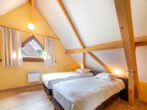 - 2 lits dans une chambre mansardée dans l'établissement Cozy Retreat with Shared Pool, à Lacapelle-Marival