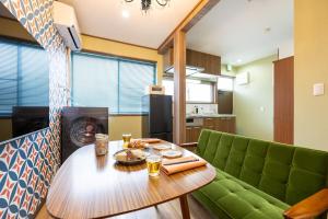 a living room with a table and a green couch at 長期ステイ歓迎 ポップ ディズニー風 TDR スカイツリー好アクセス 定員3名 東京駅10分 駐車場予約 送迎有 HOTEL DREAM MUSIC Tōyōchō japanese-pop in Tokyo