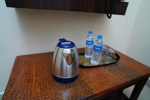 a tea kettle and two bottles of water on a table at Harish Beach Resort in Rāmeswaram