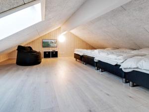 a attic room with two beds and a large window at 5 star holiday home in Ringkøbing in Ringkøbing