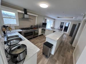a kitchen with a sink and a stove top oven at Happy Haven Lodge I Shared Rooms in Newnham