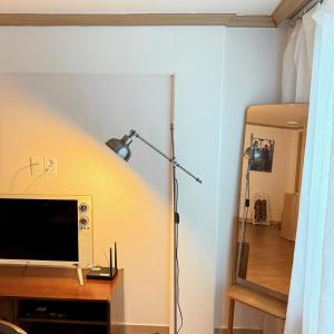 Habitación con TV y escritorio con lámpara. en Magnolia Wonju branch, en Wonju 10 fotos más