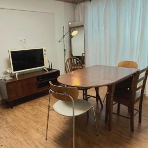 Un comedor con mesa y sillas y un televisor. en Magnolia Wonju branch, en Wonju