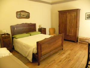 um quarto com uma cama grande e pisos em madeira em B&B Il Mulino em Sanfront