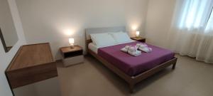 a bedroom with a bed with two shoes on it at My Home Apartments in Matera