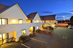 a building with a car parked in a parking lot at Bella Vista Motel Gisborne in Gisborne