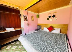 a bedroom with a large bed with pink walls at Terrace House Tả Van in Sa Pa