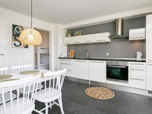 a kitchen with white cabinets and a table with chairs at 5 star holiday home in Bogense in Bogense